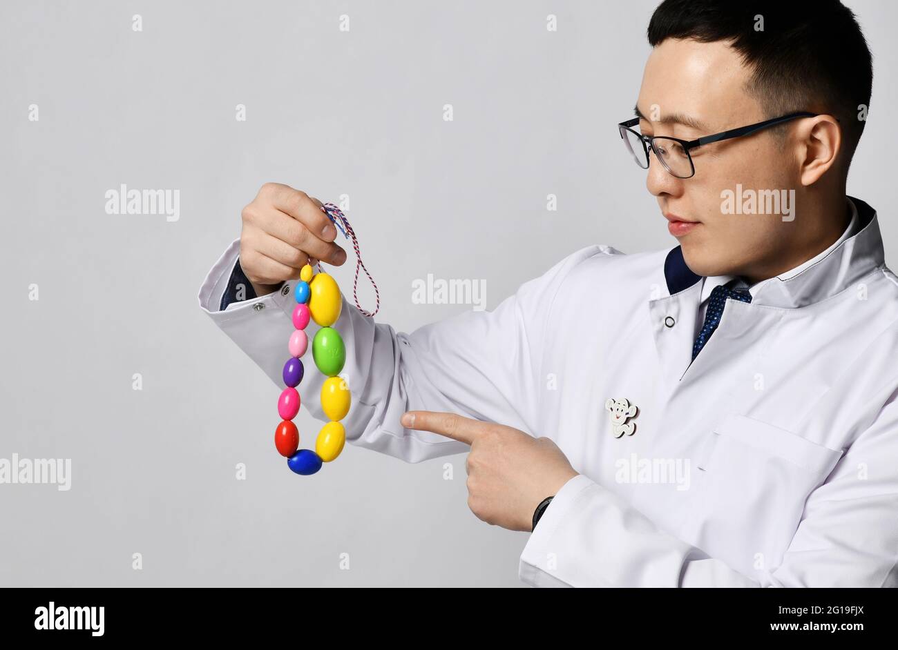 Urologisches proktologisches Konzept. Mann Arzt Urologe oder Proktologe in weißen traditionellen Uniform halten männlichen Hoden zu Stockfoto