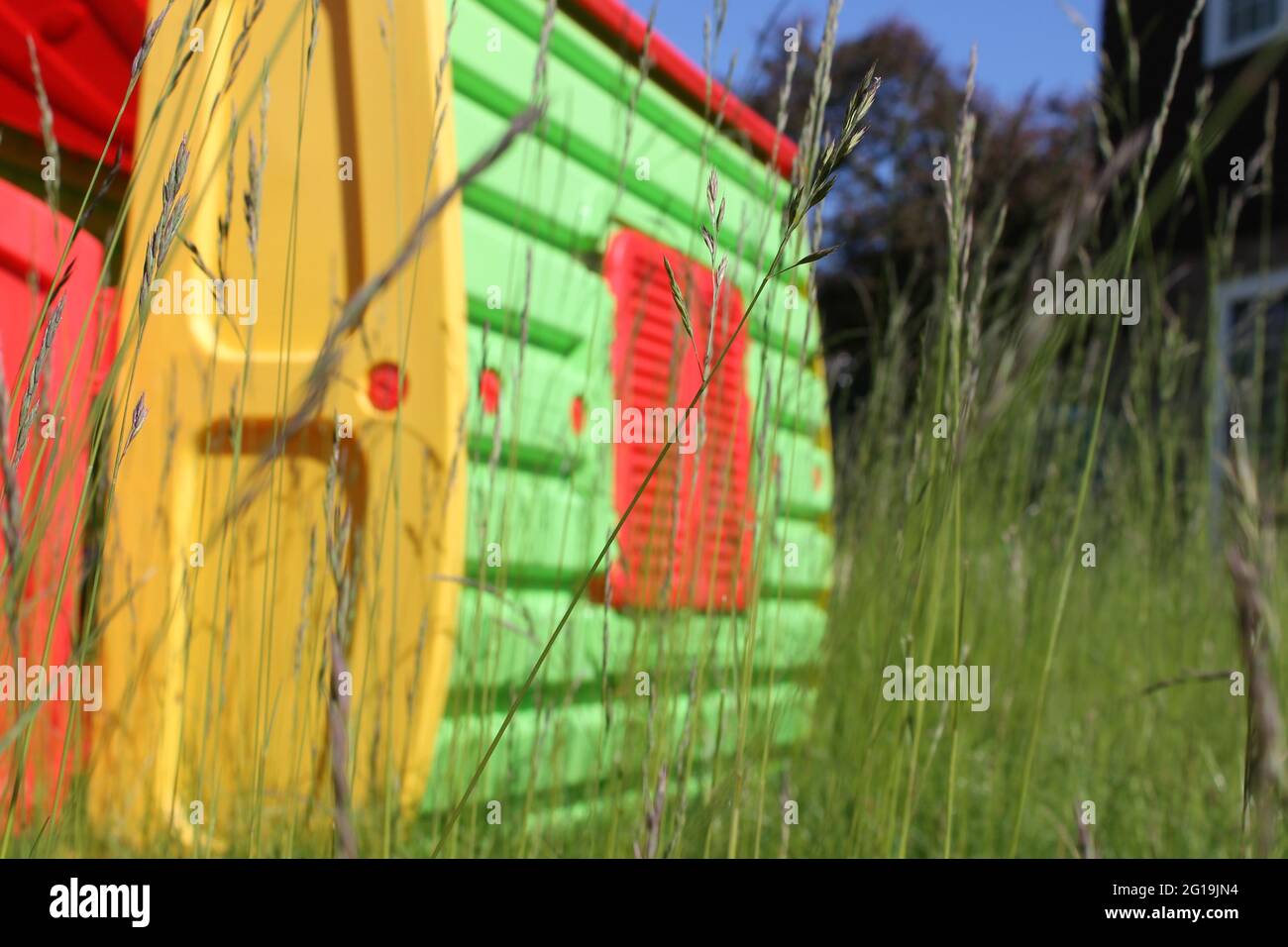 Kinderspielhaus in einem langen, mit Gras bewachsenen Garten Stockfoto