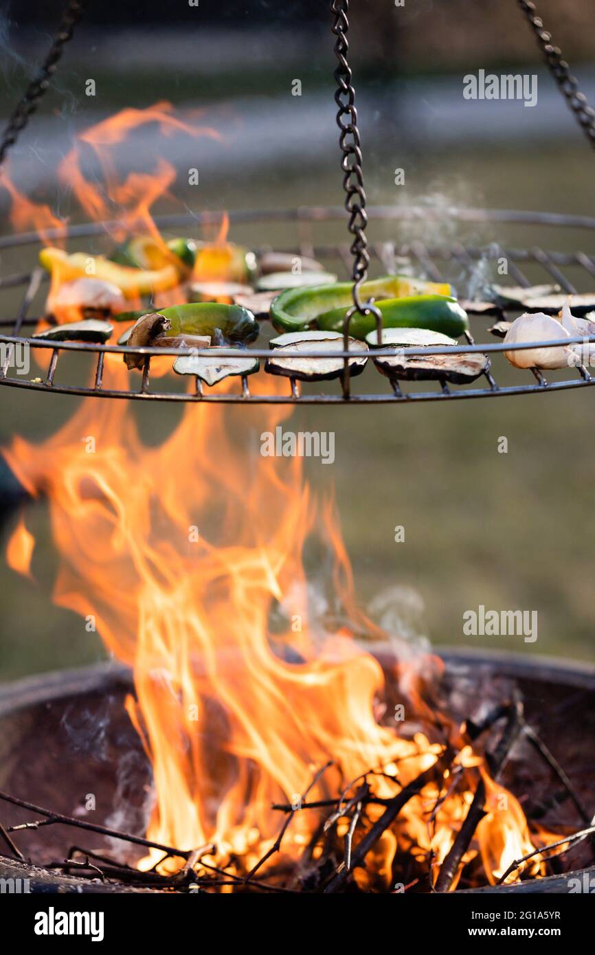 Gegrilltes Gemüse und große Flammen des Feuers, Eisen Grill Stockfoto
