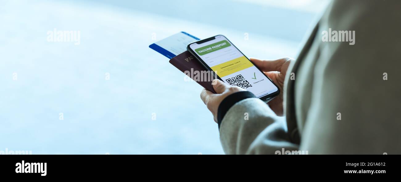 Nahaufnahme einer Frau mit elektronischem Impfpass am Telefon mit Pass und Flugticket am Flughafen. Covid-19 Immunität e-Pass im smart Stockfoto