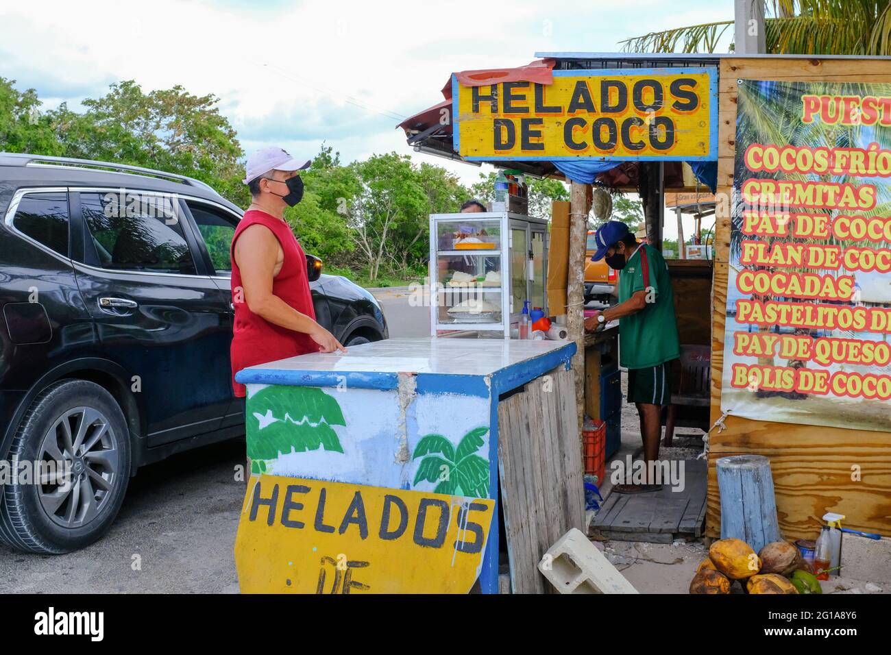 Es wird geschätzt, dass in Mexiko über 600,000 Menschen an Covid-19 (Daten vom Mai 2021) gestorben sind. Viele mexikanische Menschen haben Freunde und Verwandte durch die Krankheit verloren. Überall in Mexiko gibt es vorbeugende Gesundheitsmaßnahmen, um die Ausbreitung des Coronavirus zu verlangsamen. In einem kleinen Laden am Straßenrand wie diesem in Yucatan: Die Kunden und Unternehmer tragen Gesichtsmasken und es gibt ein Händedesinfektionsmittel. Alle kleinen Unternehmen treffen Vorsichtsmaßnahmen, während sie versuchen, offen zu bleiben, um zu überleben Stockfoto