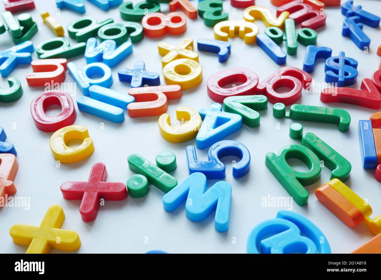 Bunte Plastikbuchstaben auf weißem Hintergrund, Nahaufnahme Stockfoto