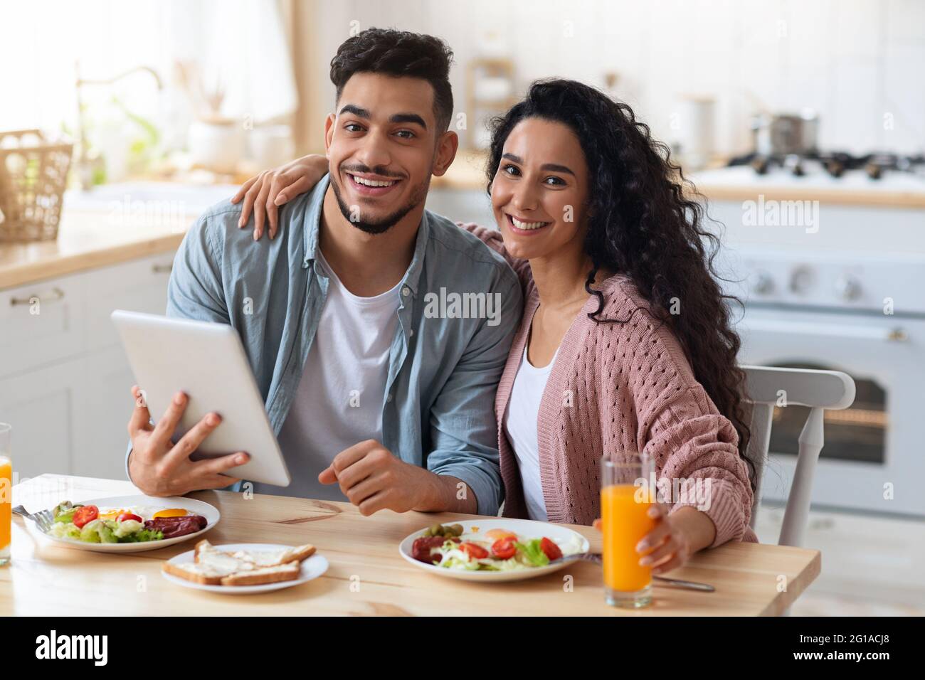 Portrait Von Glücklichen Arabischen Ehepartnern Surfen Im Internet Auf Digitalem Tablet Während Des Frühstücks Stockfoto