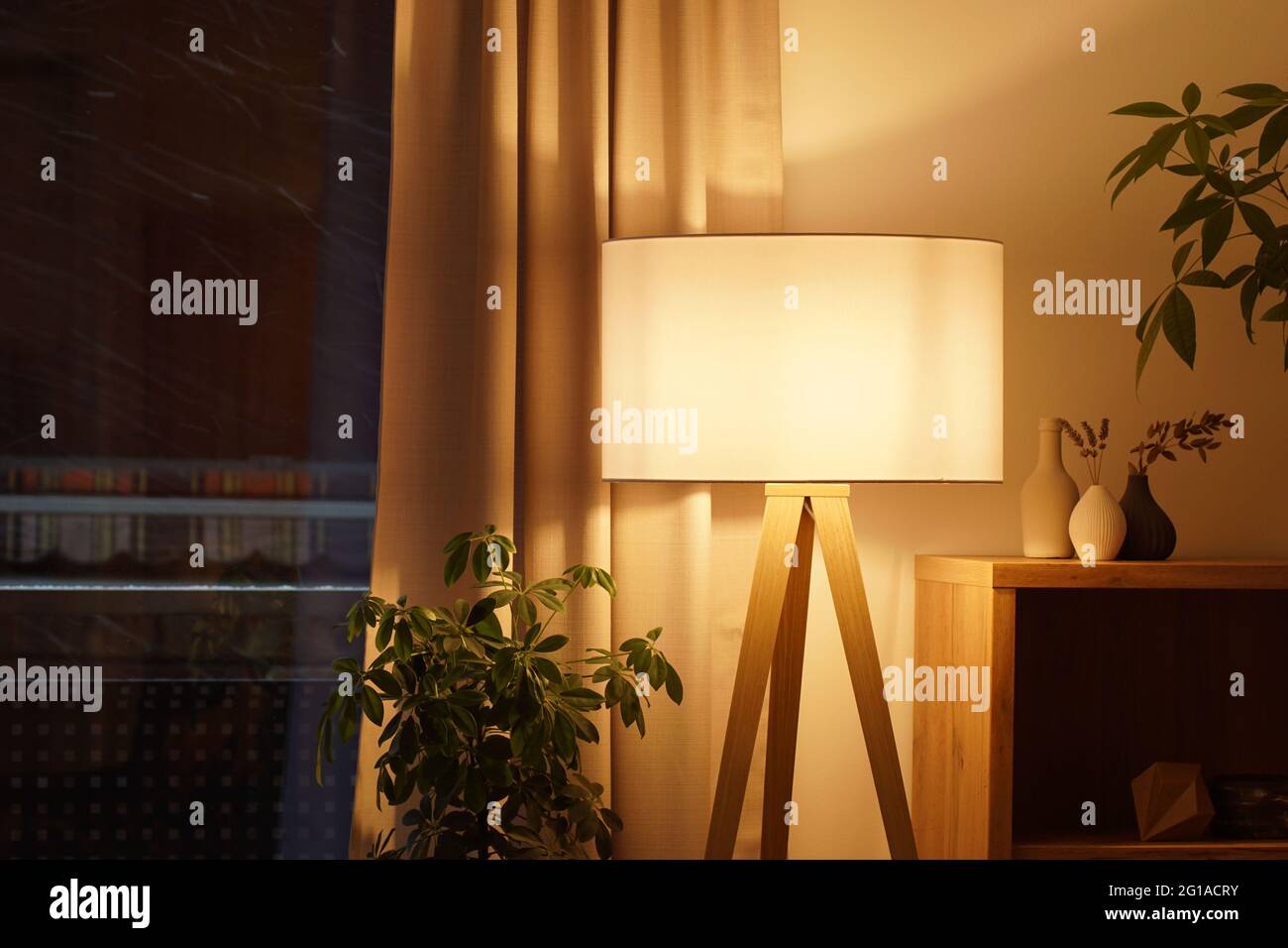 Blick auf die Stativlampe in einem gemütlichen Wohnzimmer, das warmes Licht ausgibt Stockfoto