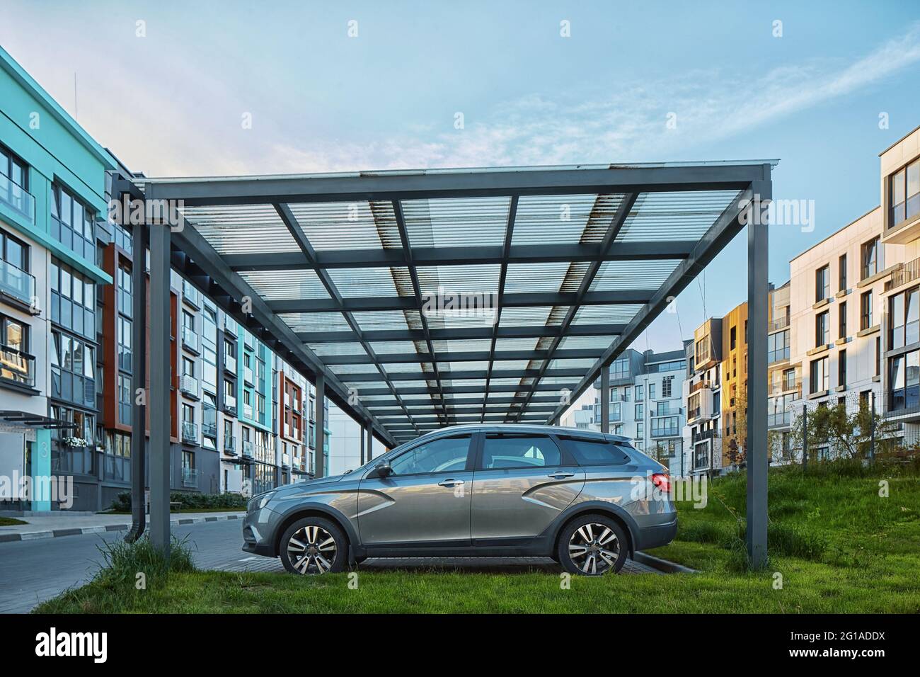 New Metal Carport für öffentliche Fahrzeug Parken vor Multi Wohngebäude. Parkplatz im Freien mit Auto. Stockfoto