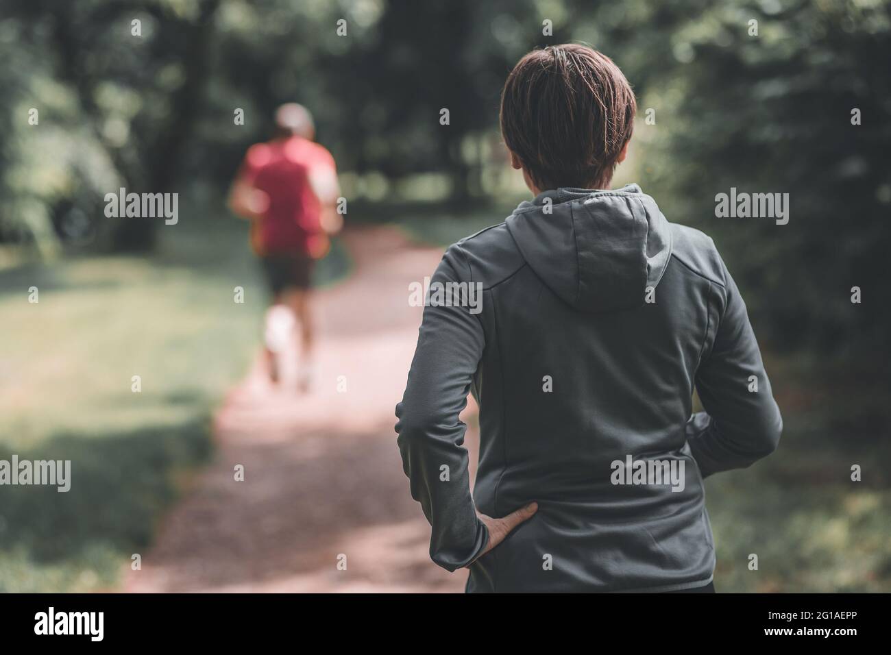 Rückansicht einer erwachsenen Joggingspielerin im Park, die in den 40er Jahren zum Laufen auf der Rennstrecke, zum gesunden Lebensstil und zur Freizeitbeschäftigung bereit ist Stockfoto