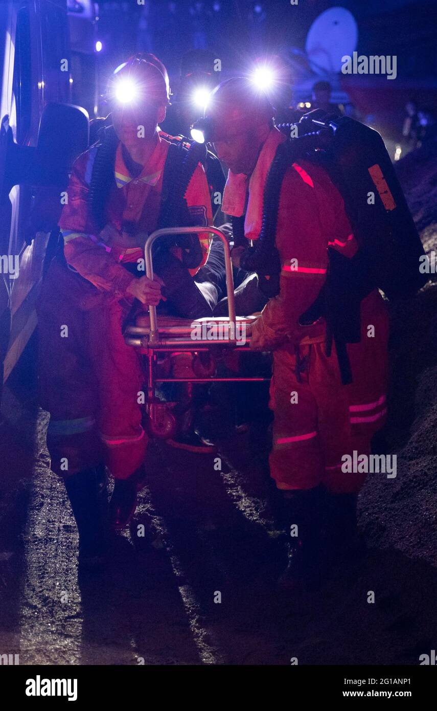 (210606) -- JIXI, 6. Juni 2021 (Xinhua) -- Retter überführen einen Bergmann vom Standort eines Kohlebergwerks-Unfalls in der Stadt Jixi in der nordöstlichen Provinz Heilongjiang, 6. Juni 2021 in einen Krankenwagen. Alle acht Bergleute, die nach einem Kohle- und Gasausbruch in der Stadt Jixi in der nordöstlichen Provinz Heilongjiang in einer Kohlemine gefangen waren, wurden zu Boden gehoben, sagten Retter am Sonntag. Der Unfall ereignete sich am Samstag um 12:07 Uhr in der Kohlemine, die von der Jixi-Niederlassung der Longmay Mining Holding Group Co. Ltd. Betrieben wird, als die acht Bergleute unter Tage arbeiteten. Gegen 8:00 Uhr, alle e Stockfoto