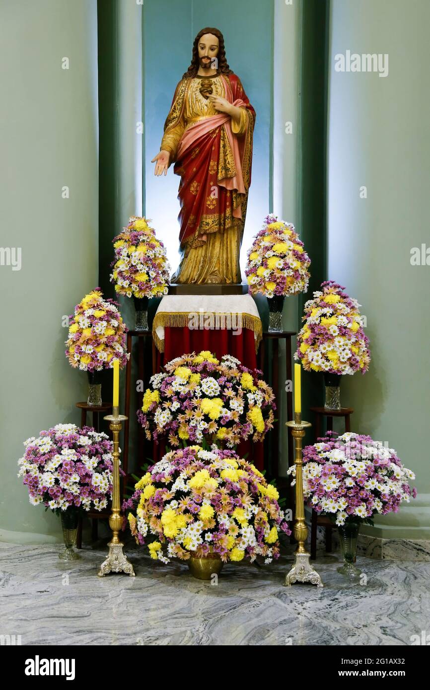 Das heilige Herz Jesu auf einem geschmückten und geblümten Altar Stockfoto