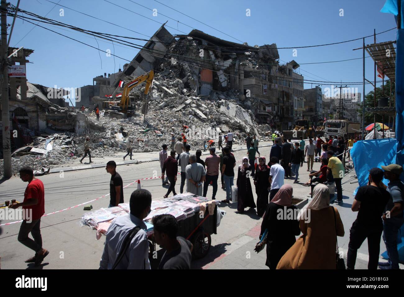 Gaza, Gaza. Juni 2021. Palästinenser gehen in der Nähe von Arbeitern ...