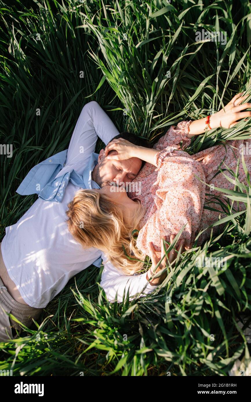 Junges Paar mit Picknick auf der Wiese an hellen sonnigen Tag. Mann und Frau genießen die Gesellschaft des anderen Stockfoto