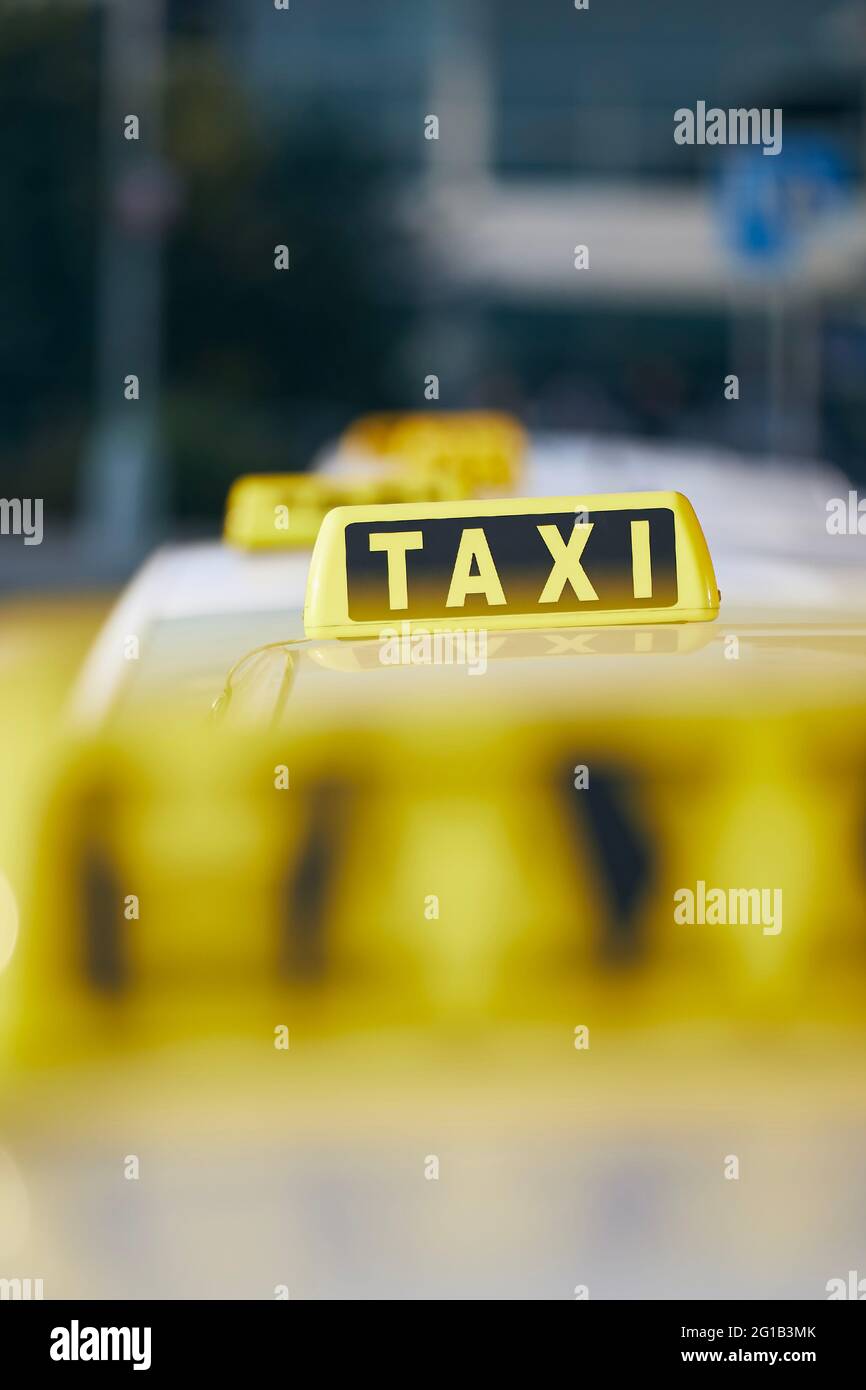 Selektiver Fokus auf Taxi-Schild auf dem Dach.; Auto wartet auf Passagier in der City Street. Stockfoto