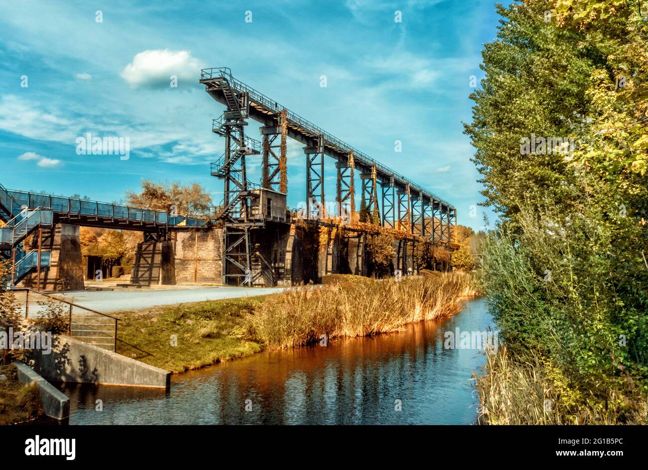 Brückenpromenade am alten Emscher inmitten des Landschaftsparks Duisburg Nord - Industriemaschinen und rostige Komponenten - Eisenwerke. Stockfoto