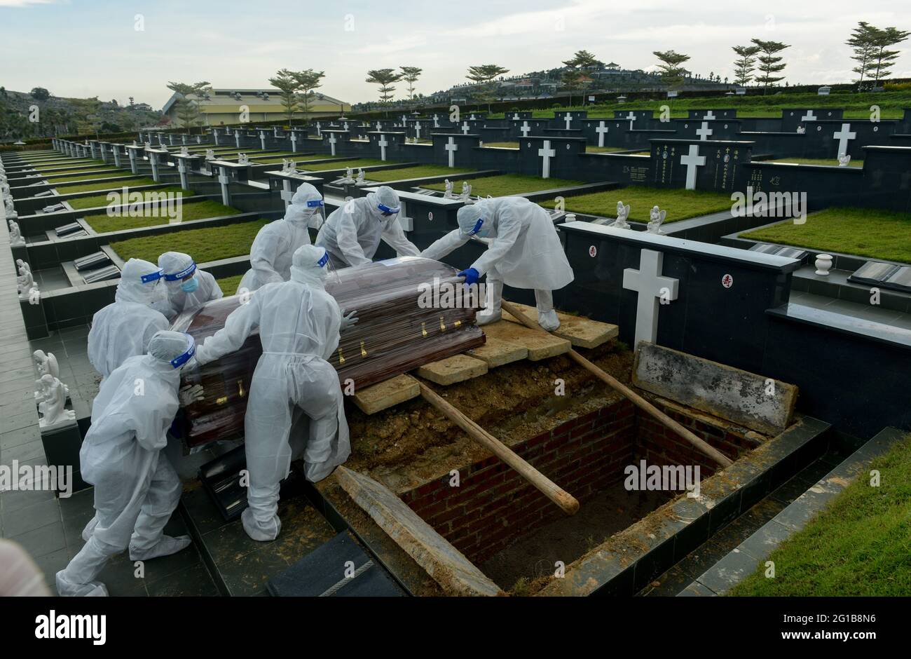 Klang, Selangor, Malaysia. Juni 2021. Mitarbeiter des Bestattungsdienstes, die persönliche Schutzausrüstung tragen, bereiten sich darauf vor, den Sarg eines Opfers der Coronavirus-Krankheit (COVID-19) auf dem Friedhof zu begraben. Kredit: Keepy/ZUMA Wire/Alamy Live Nachrichten Stockfoto