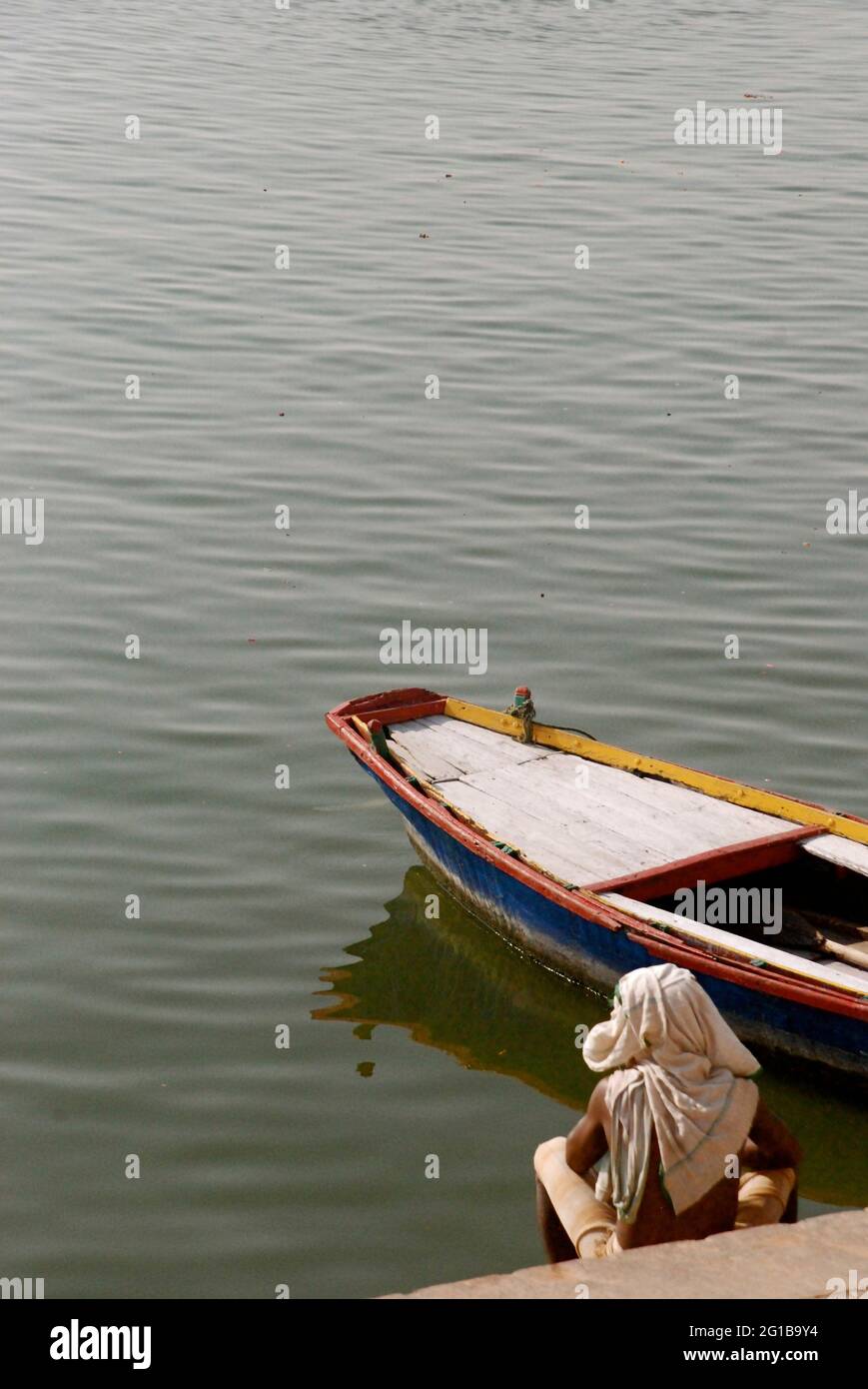 Ein Bootsmann wartet geduldig auf Kunden von der Bank des Ganges in Varanasi, Indien. 9. April 2007. Stockfoto