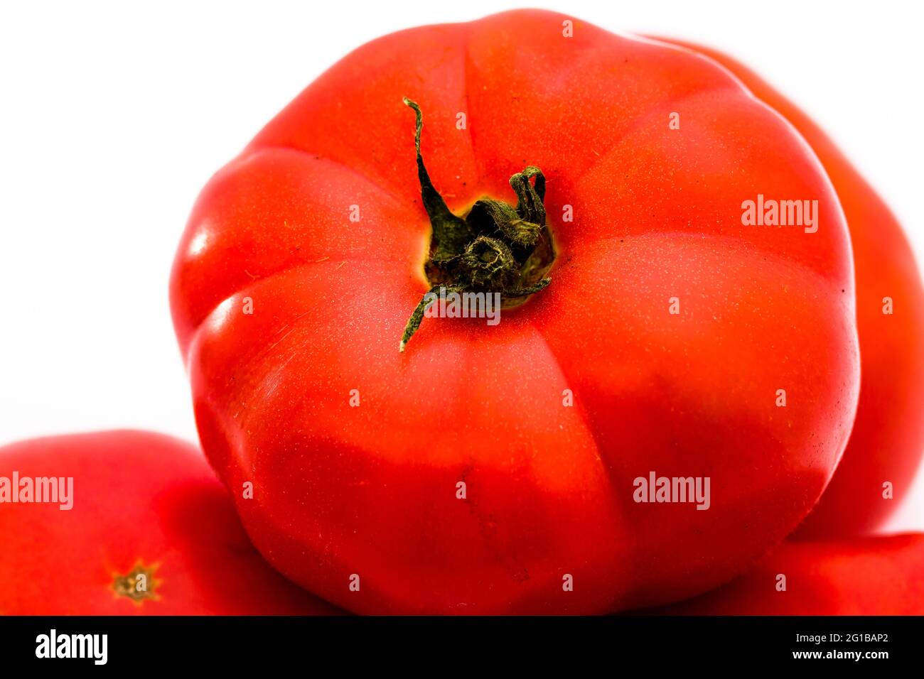 Eine frische, leckere und rote Tomate, isoliert auf weißem Hintergrund Stockfoto