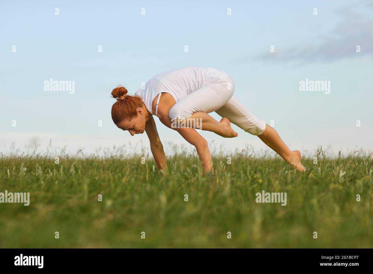 Frau, die Yoga gegen den Abendhimmel praktiziert Stockfoto