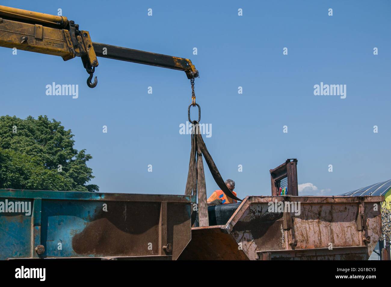 Dnepropetrovsk, Ukraine - 05.28.2021: Müllcontainer mit einem Kran in einen LKW laden. Slinger funktioniert. Stockfoto