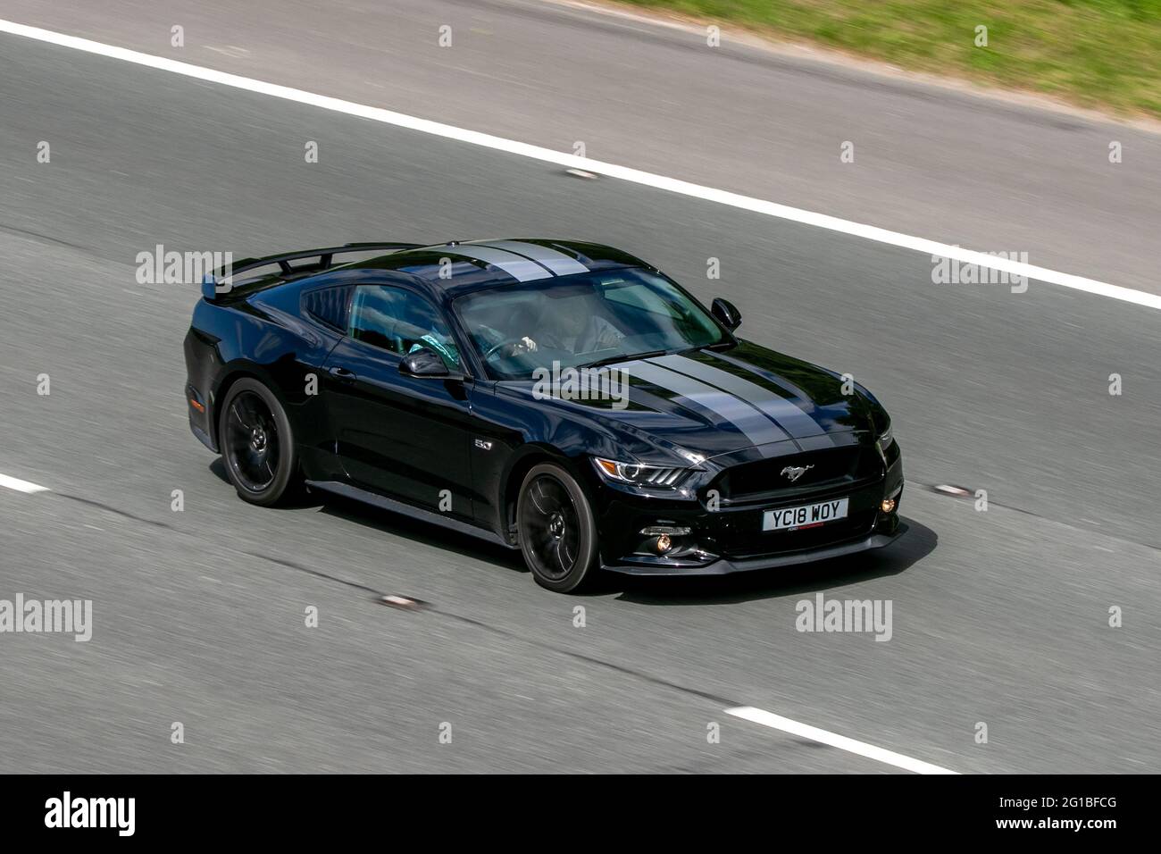 2018 schwarzes Ford Mustang GT 4951cc Benziner Coupé, auf der Autobahn M6 in der Nähe von Preston in Lancashire, Großbritannien. Stockfoto