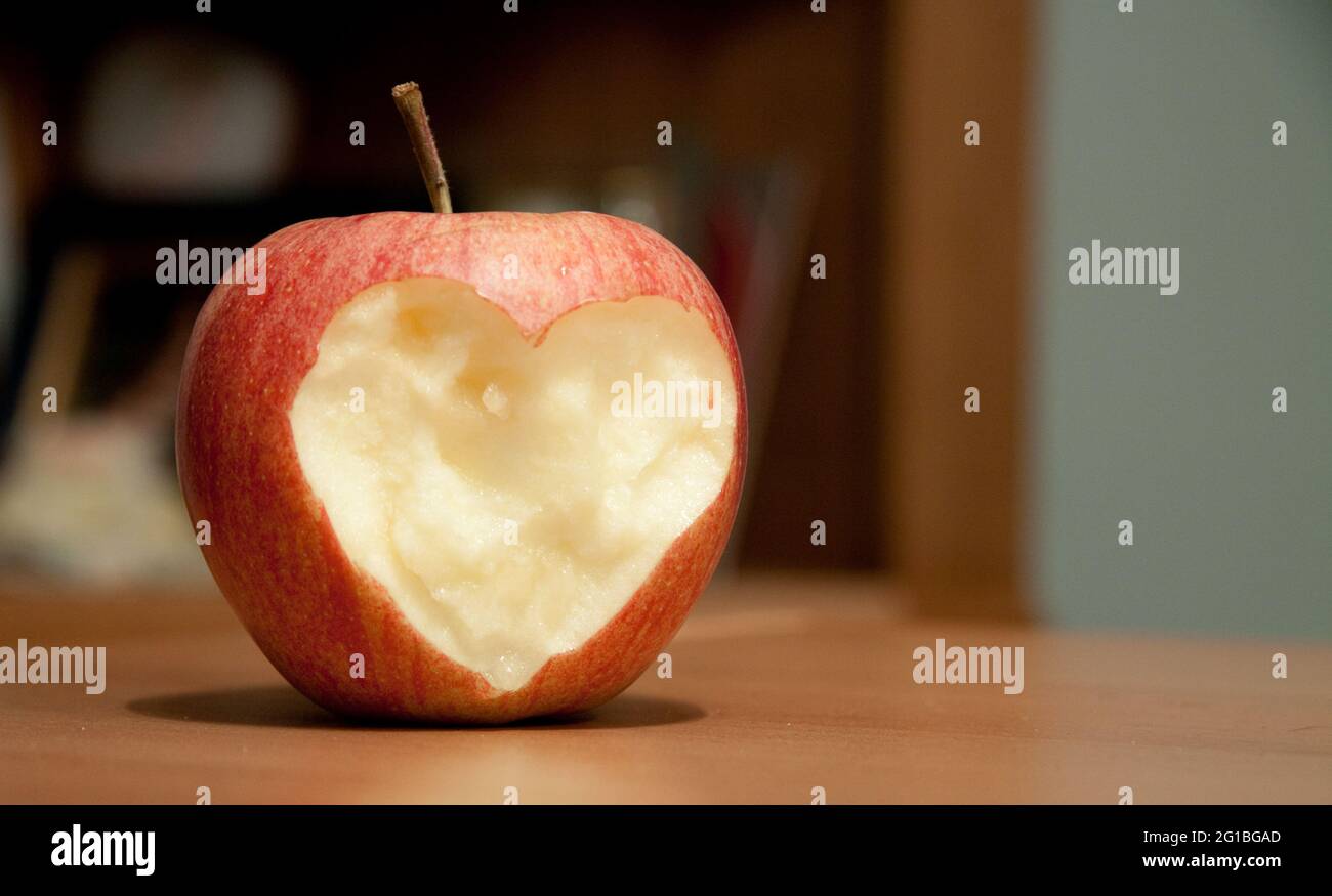 Nahaufnahme eines roten Apfels mit herzförmigem Ausschnitt Stockfoto