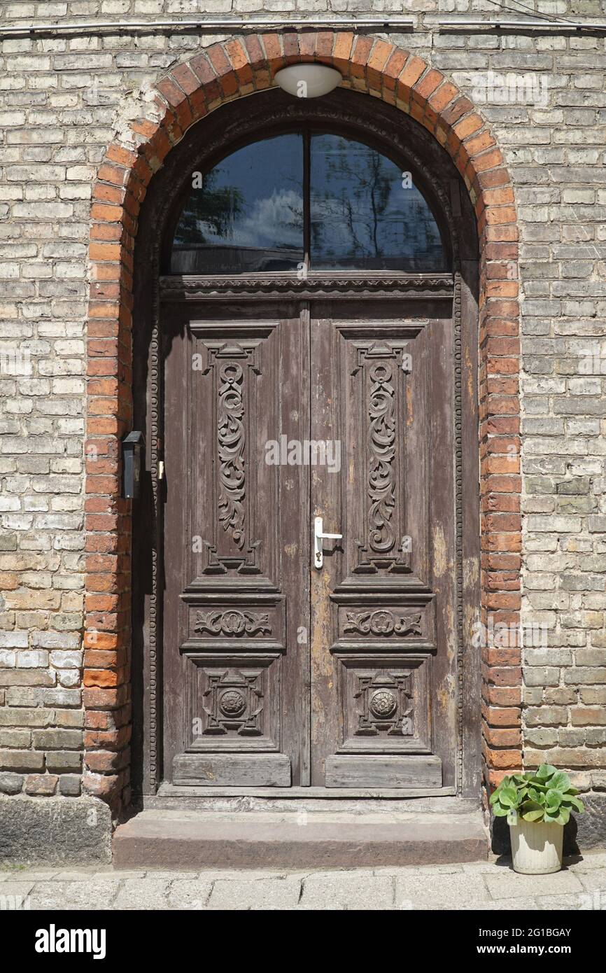 Alte hölzerne geschnitzte Doppeltür, Backsteingebäude Eingang. Bialystok, Polen, Europa. Stockfoto