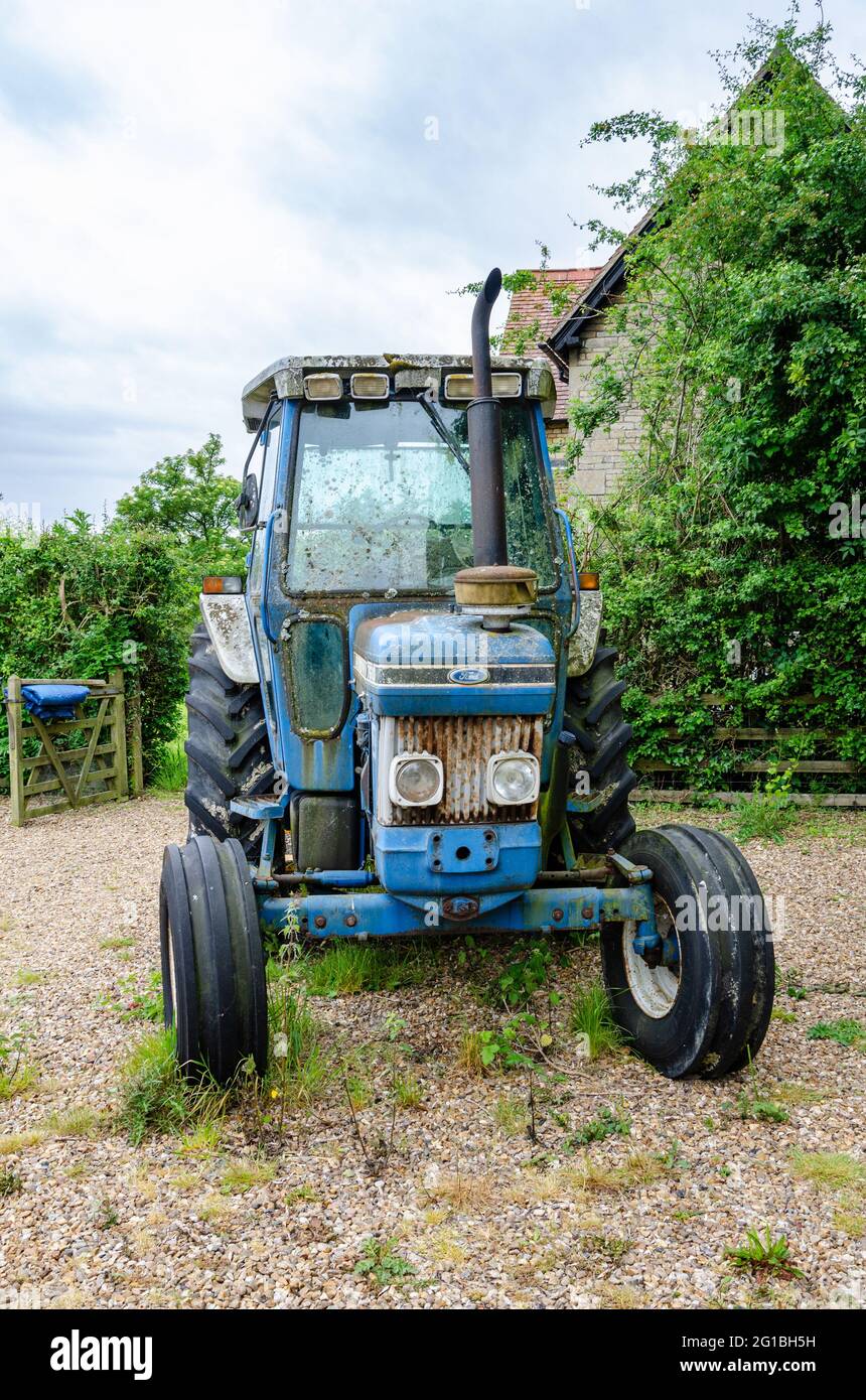 Ein blauer Ford 7610 Traktor, der auf einer Schottereinfahrt geparkt ist. Stockfoto
