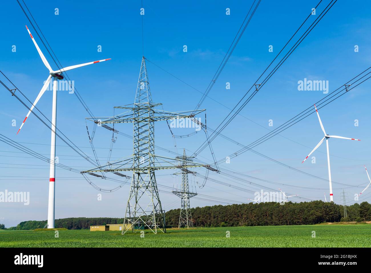 Windturbinen, Strommasten mit Stromleitungen Stockfoto