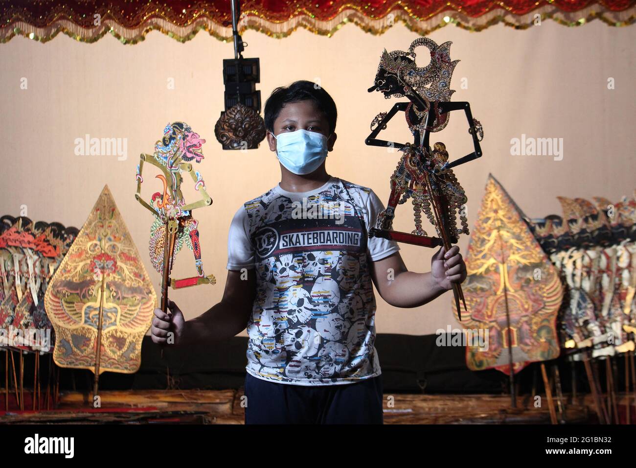 Sandi ist 12 Jahre alt, trägt eine Maske und praktiziert als Puppenspieler  im Nirmalasari Studio, cinere, Depok, West Java, Indonesien. Das  Nirmalasari Art Studio, das am 1. Juni 1987 gegründet wurde, wurde