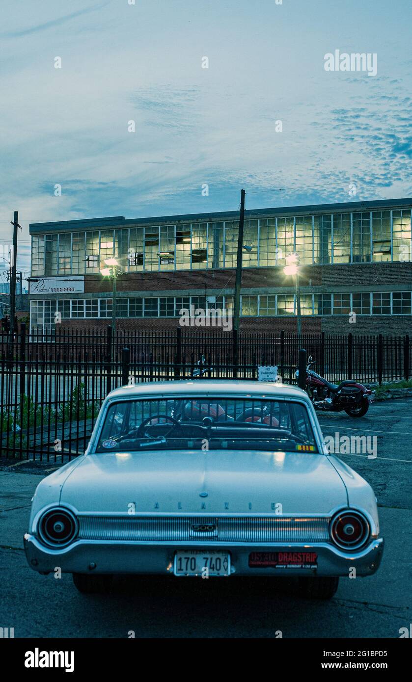 Klassisches amerikanisches Auto mit urbanem Hintergrund in Chicago, IL, USA.das klassische amerikanische Ford Galaxie Auto parkte vor einem alten Industriegebäude Stockfoto