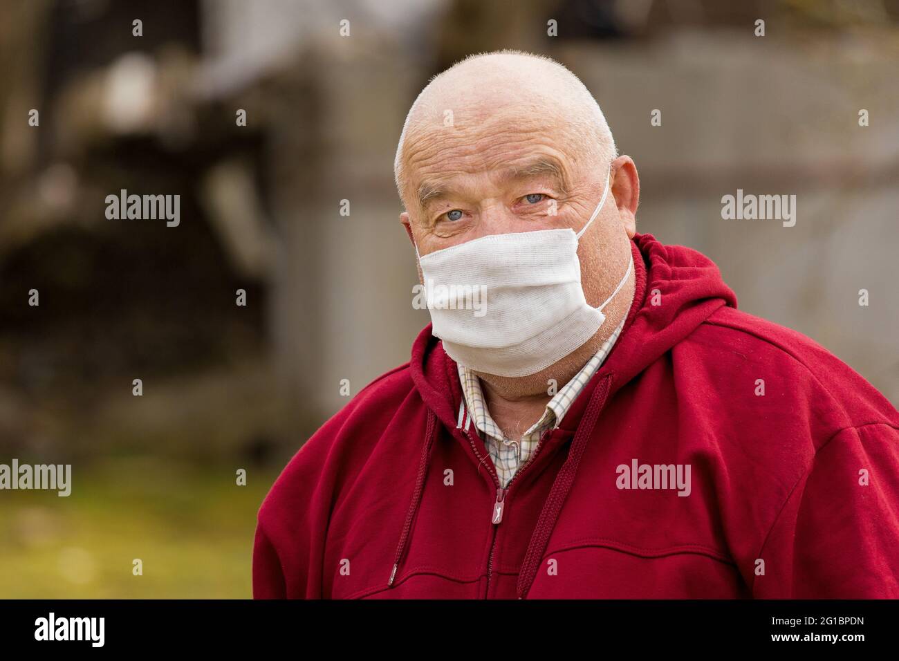 Porträt eines älteren europäischen Mannes mit einem kurzen Haarschnitt in einer schützenden sicheren medizinischen Maske, Nahaufnahme. Stockfoto