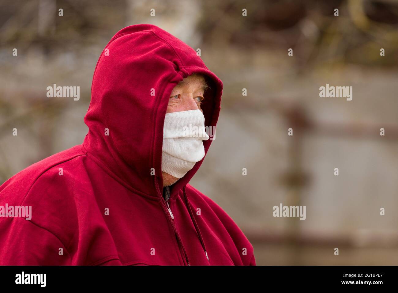 Porträt eines älteren europäischen Mannes mit einem kurzen Haarschnitt in einer schützenden sicheren medizinischen Maske, Nahaufnahme. Stockfoto
