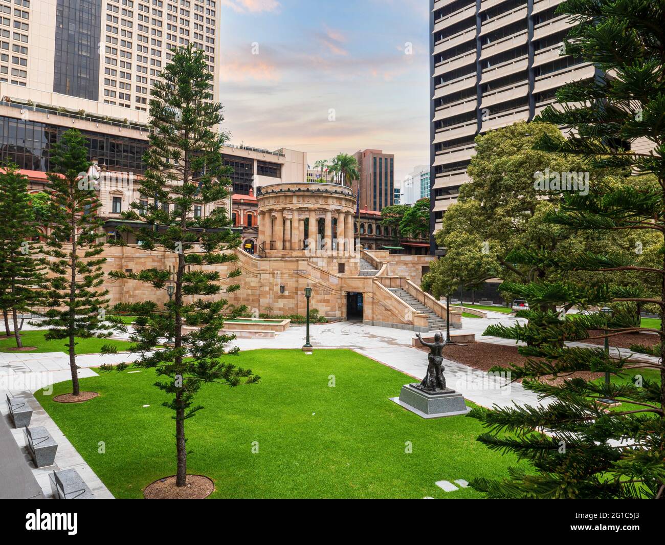 Anzac Platz und Denkmal in Brisbane, Australien. Bäume, grünes Gras, Gebäude, Statue. Stockfoto