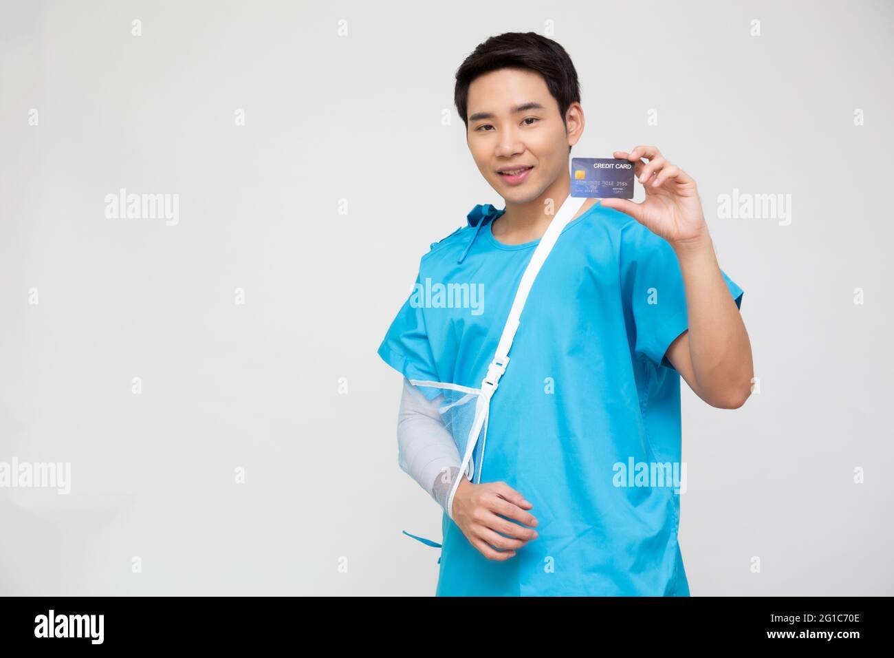 Junge asiatische Mann Patient zeigt persönliche Unfallversicherung Pflegekarte oder Kreditkarte isoliert auf weißem Hintergrund, PA und Health Claim Services concep Stockfoto