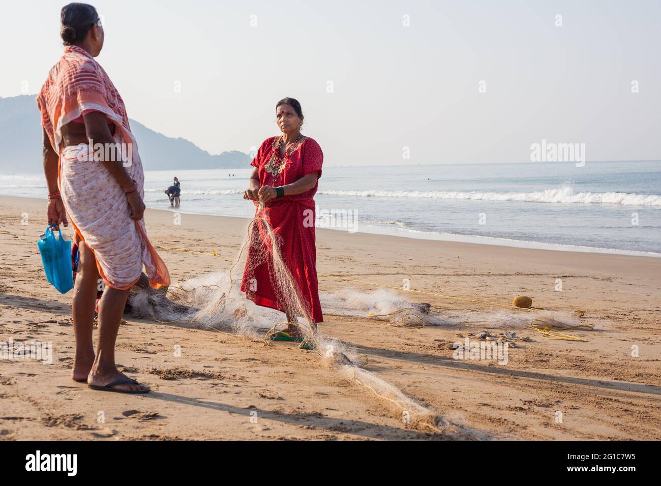 Indische Fischerin repariert ihre Fischernetze am Agonda Beach, Goa, Indien Stockfoto