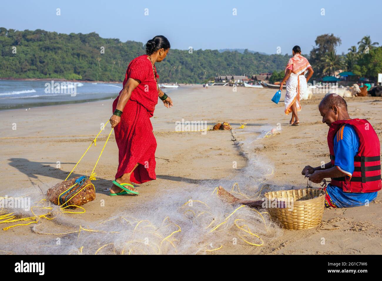 Indisches Fischerpaar repariert ihre Fischernetze am Agonda Beach, Goa, Indien Stockfoto