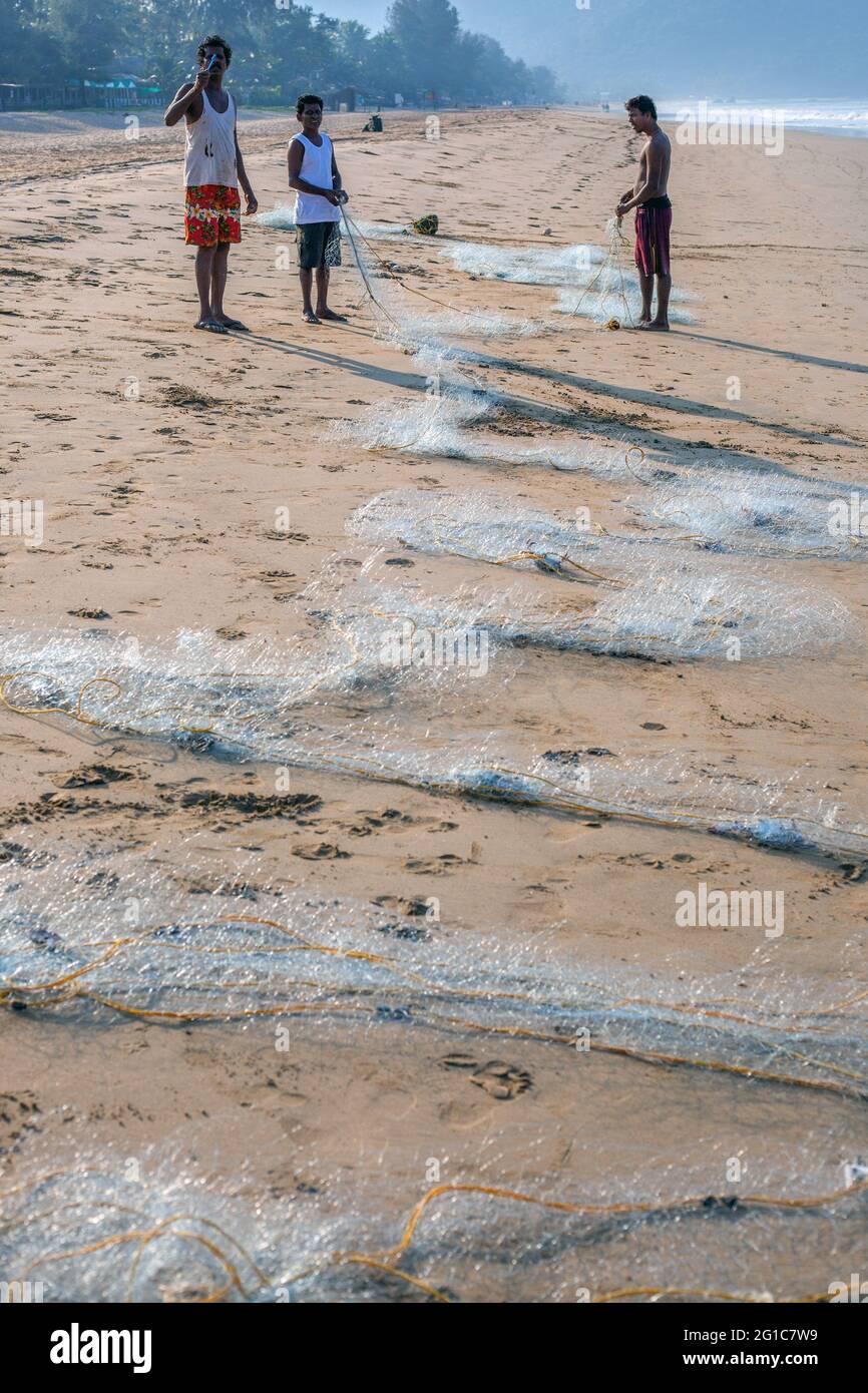 Indische Fischer reparieren ihre Fischernetze am Agonda Beach, Goa, Indien Stockfoto