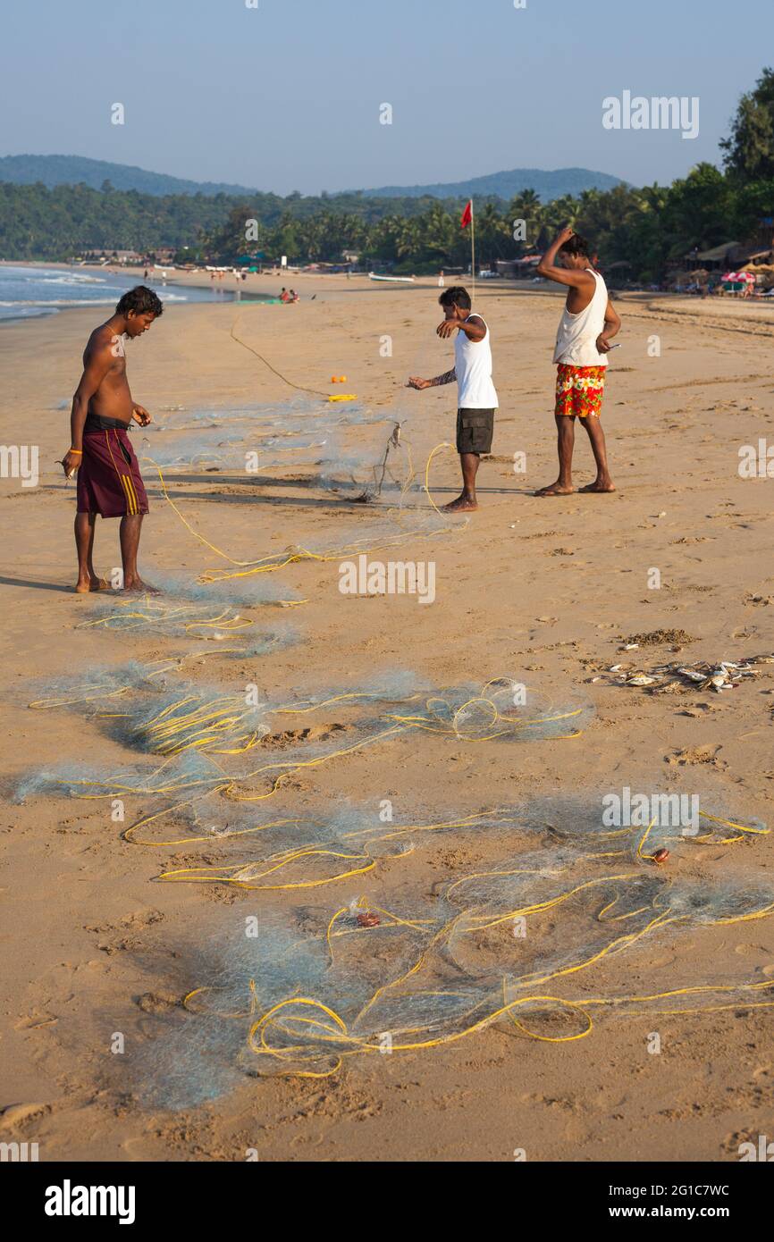 Indische Fischer reparieren ihre Fischernetze am Agonda Beach, Goa, Indien Stockfoto