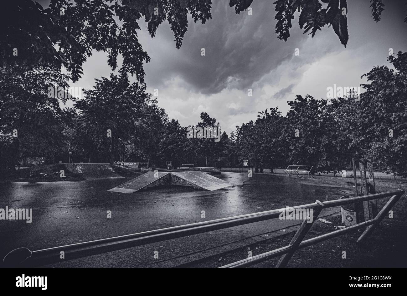 Bikepark und Skatepark auf Schloss Borbeck im verlassenen Skateboard-Park im Regen in düsterem, surreal-monochromen Schwarz-Weiß. Melantere Stimmung. Stockfoto