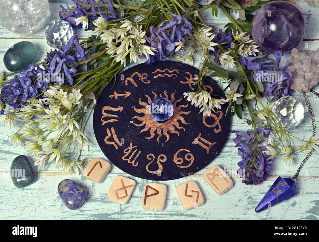 Stillleben mit schwarzem Tierkreis, Runen, Kristall und Blumen auf Hexenaltar-Tisch. Esoterischer, gotischer und okkulter Hintergrund, Halloween Mystic und wi Stockfoto