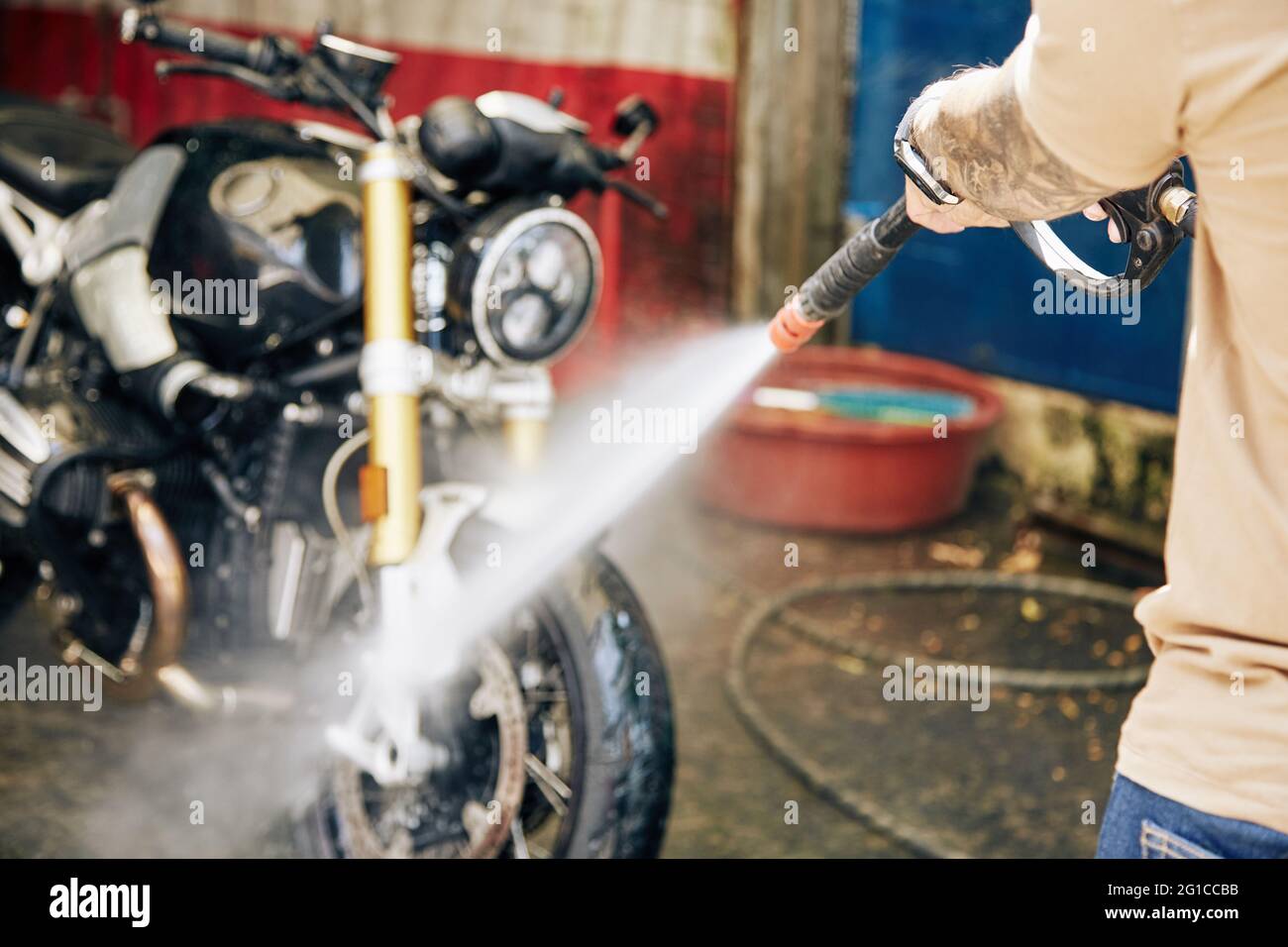Mann, der Motorrad bei der Autowäsche reinigt, selektiver Fokus Stockfoto