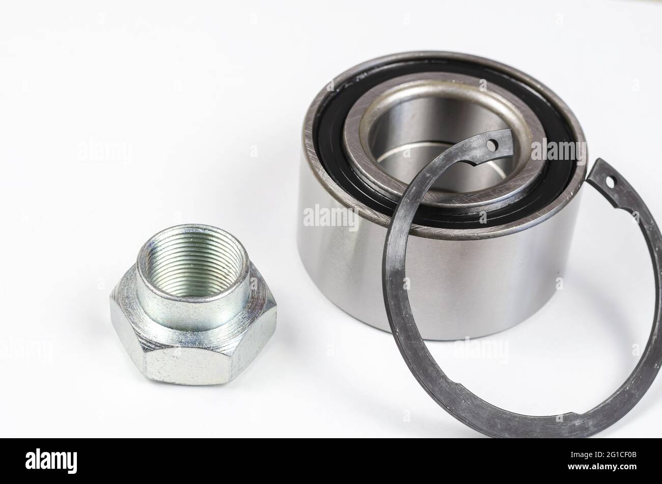 Satz von Autoteilen auf weißem Hintergrund. Neuer Sicherungsring, Sondermutter und Nabenlager. Ersatzteile, Verbrauchsmaterialien. Stockfoto