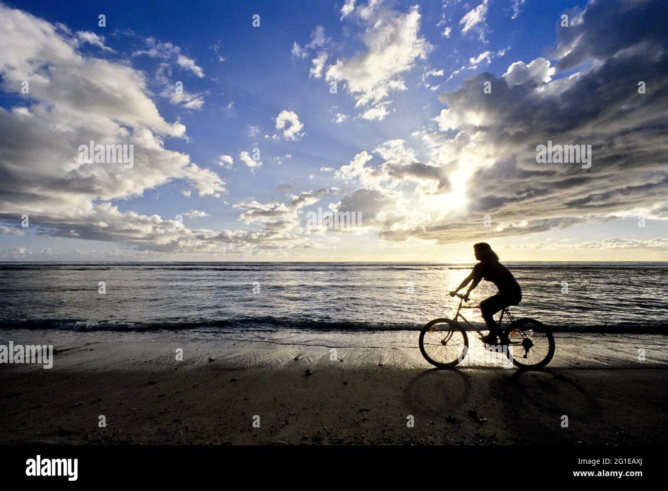 FRANKREICH. REUNION ISLAND. REITEN MIT DEM FAHRRAD AM STRAND Stockfoto