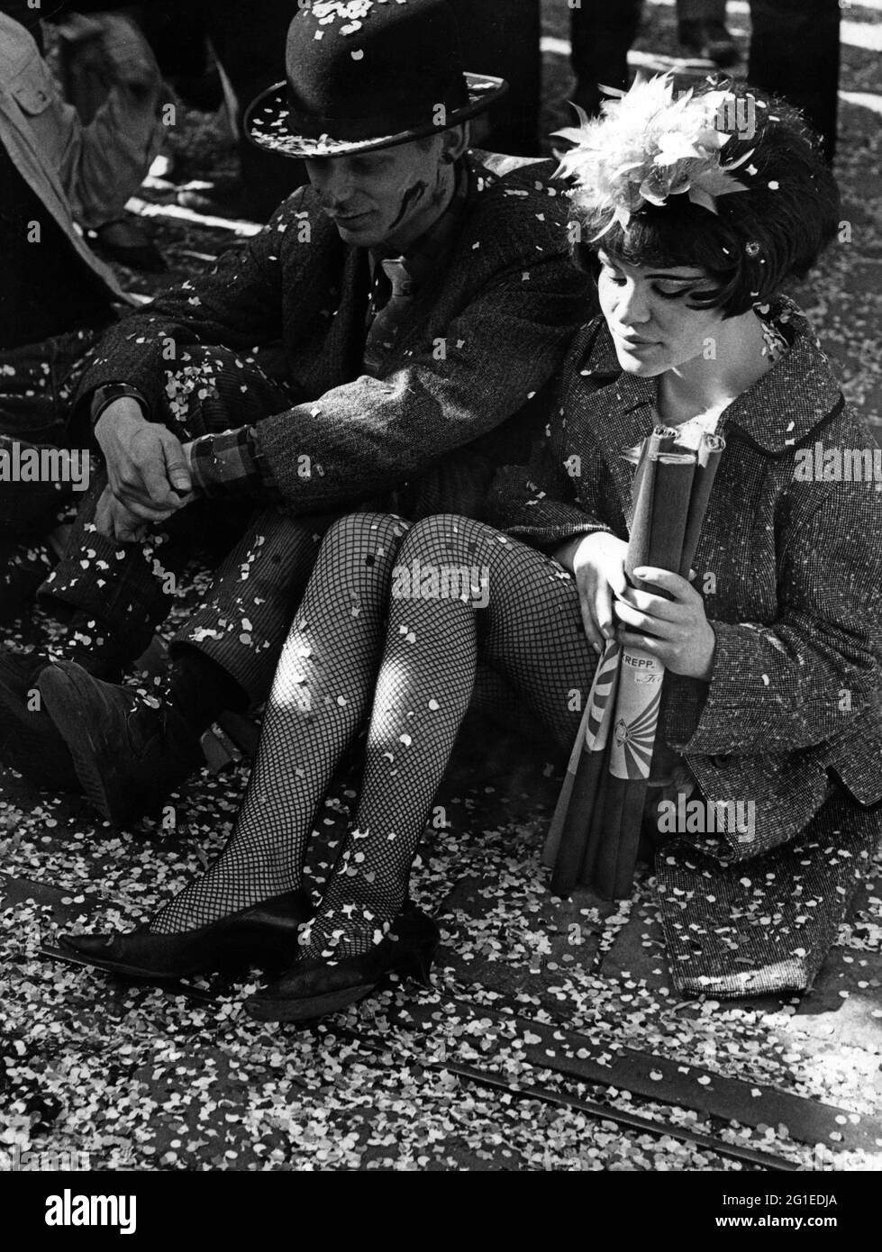 Festlichkeiten, Karneval, maskiertes Paar sitzt auf dem Bürgersteig, Deutschland, 60er Jahre, ZUSÄTZLICHE-RIGHTS-CLEARANCE-INFO-NOT-AVAILABLE Stockfoto