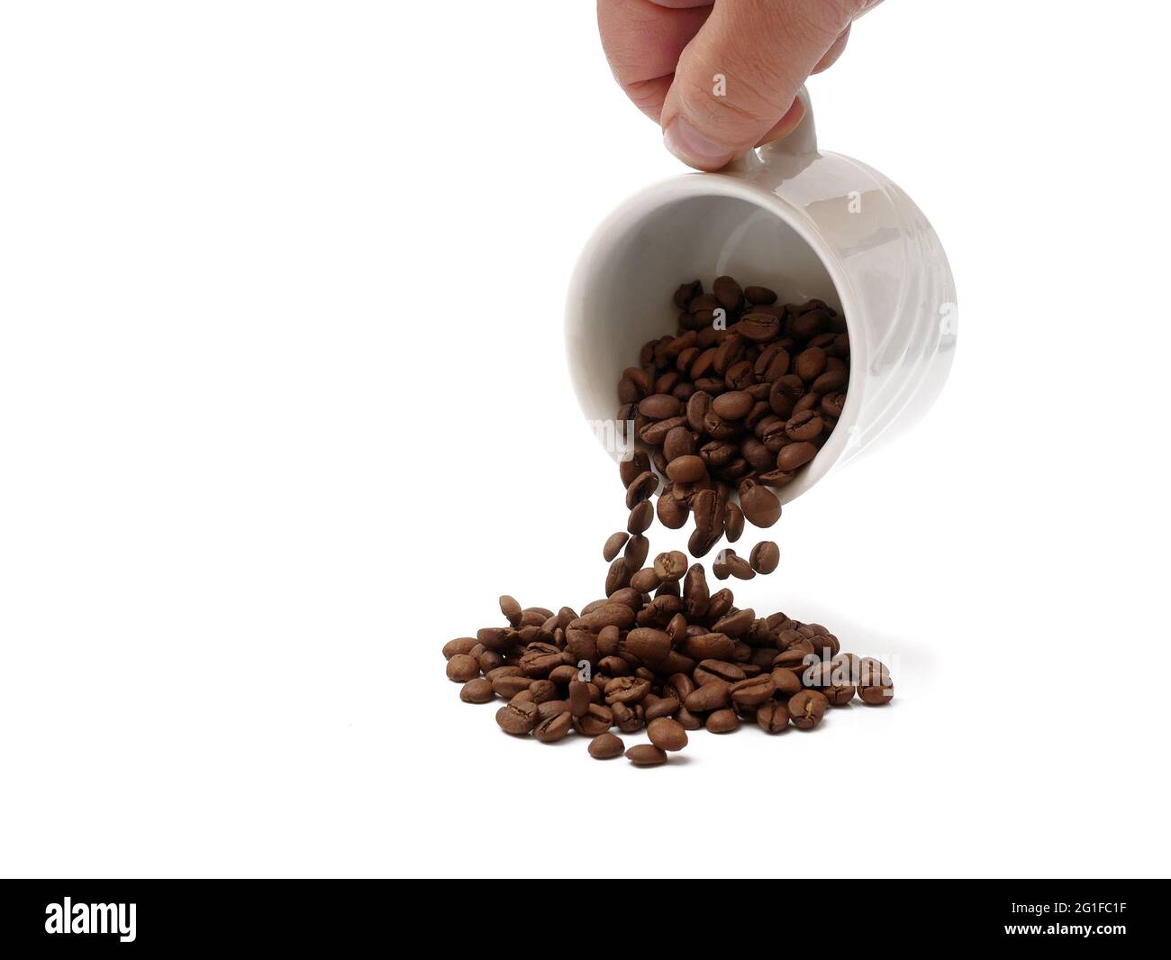 Gießen geröstete Kaffeebohnen aus Tasse isoliert auf weißem Hintergrund Stockfoto