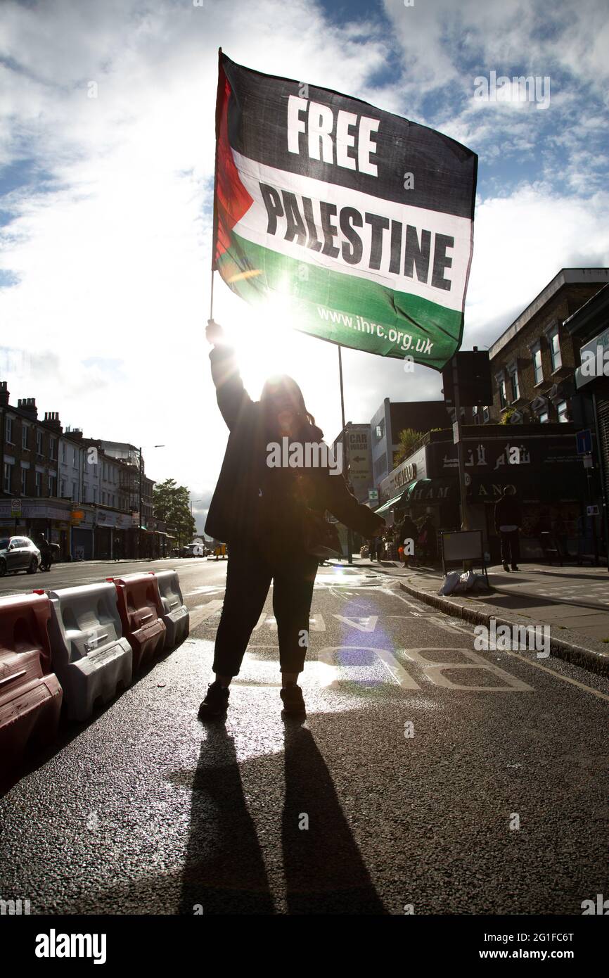 Eine Protesterin der Freiheit, die ihre Fahne schwenkt, um Palästina zu unterstützen, nach einem Protest der Freien Palästinenser in London. Mai 2021 Stockfoto