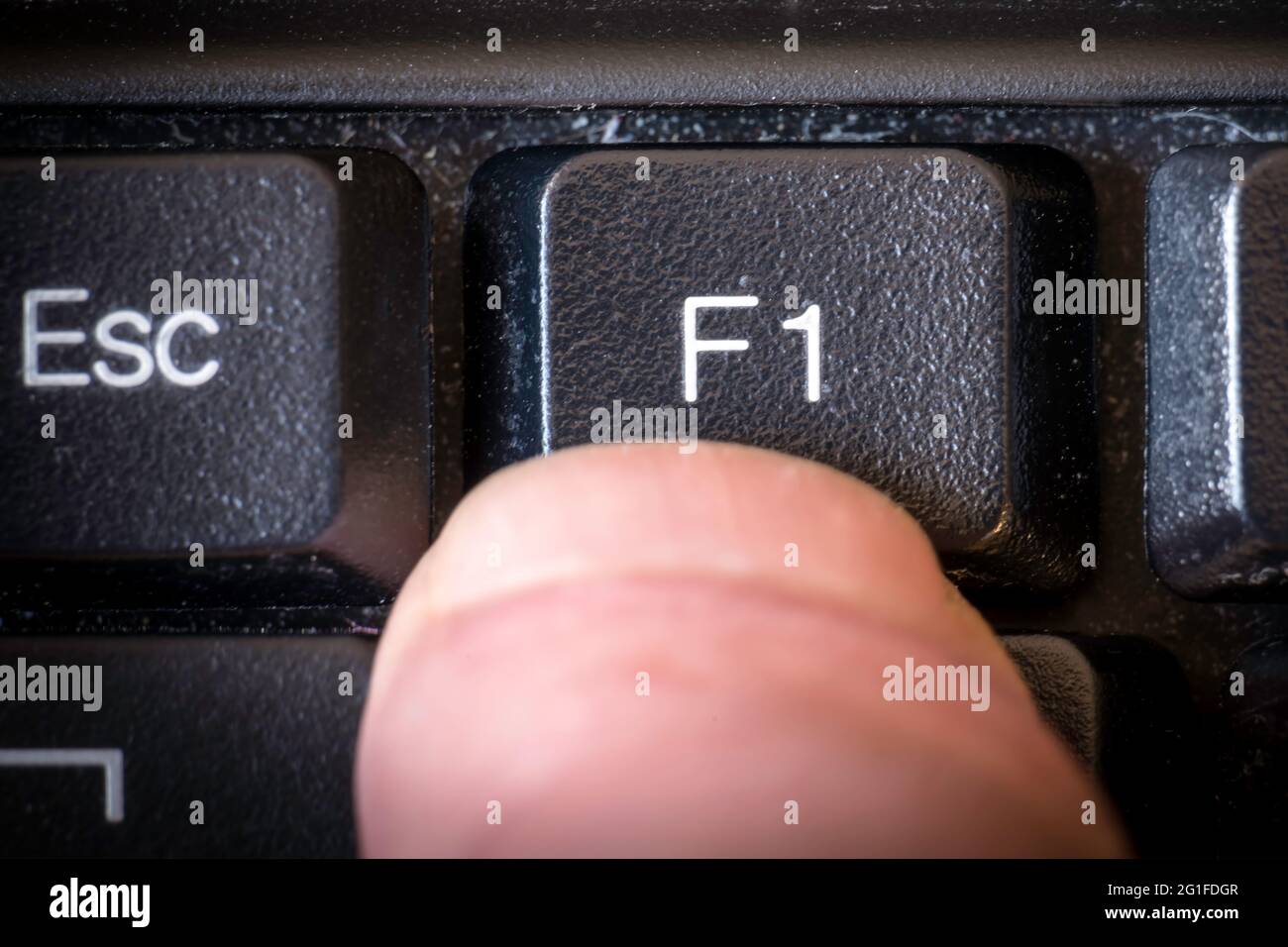 Drücken Sie F1 mit dem Finger auf der Tastatur Stockfoto