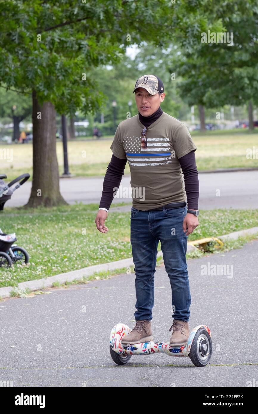 Ein gewachsener Mann auf einem Hoverboard Balance Roller. In einem Park in Queens, New York City. Stockfoto