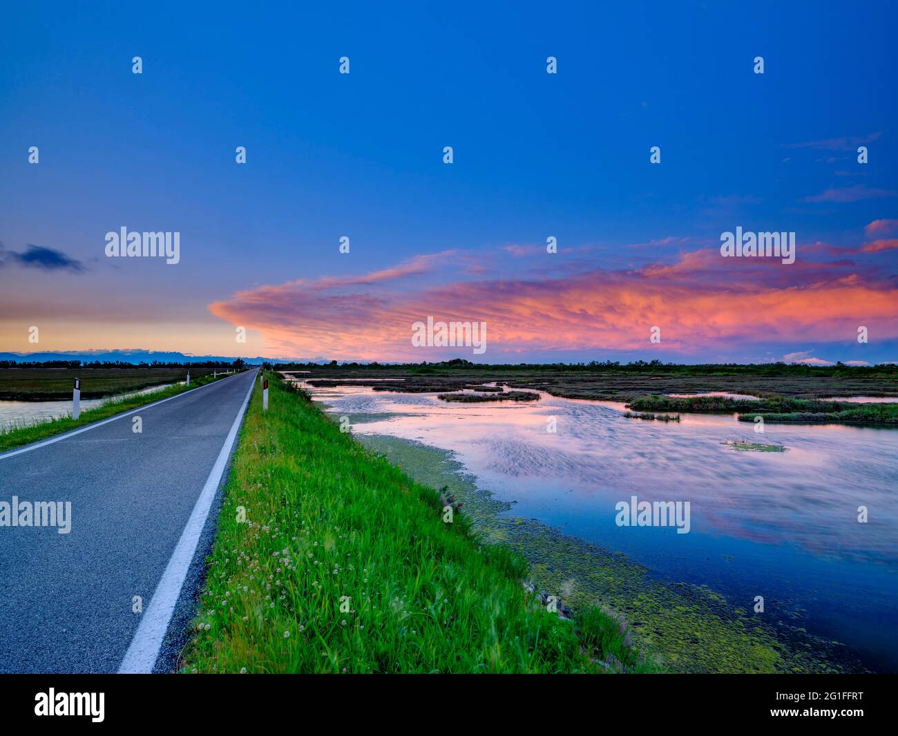 Einsame Straße und dramatische Wolken über der Lagune von Venedig, Lio Piccolo, Cavallino Treporti, Venetien, Italien Stockfoto