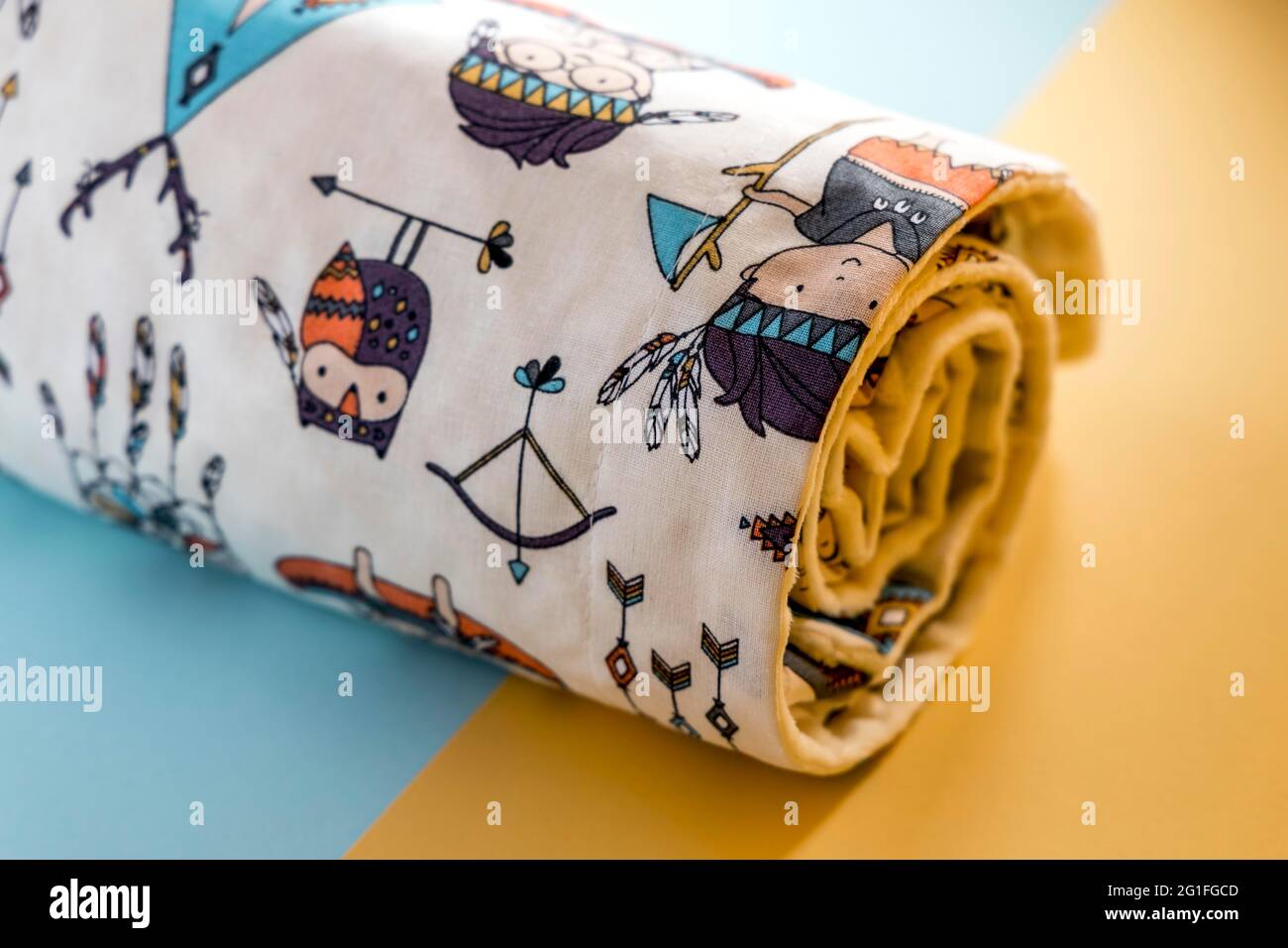 Süße und niedliche Babydecke mit indischem Muster isoliert auf Gelber und blauer Hintergrund Stockfoto