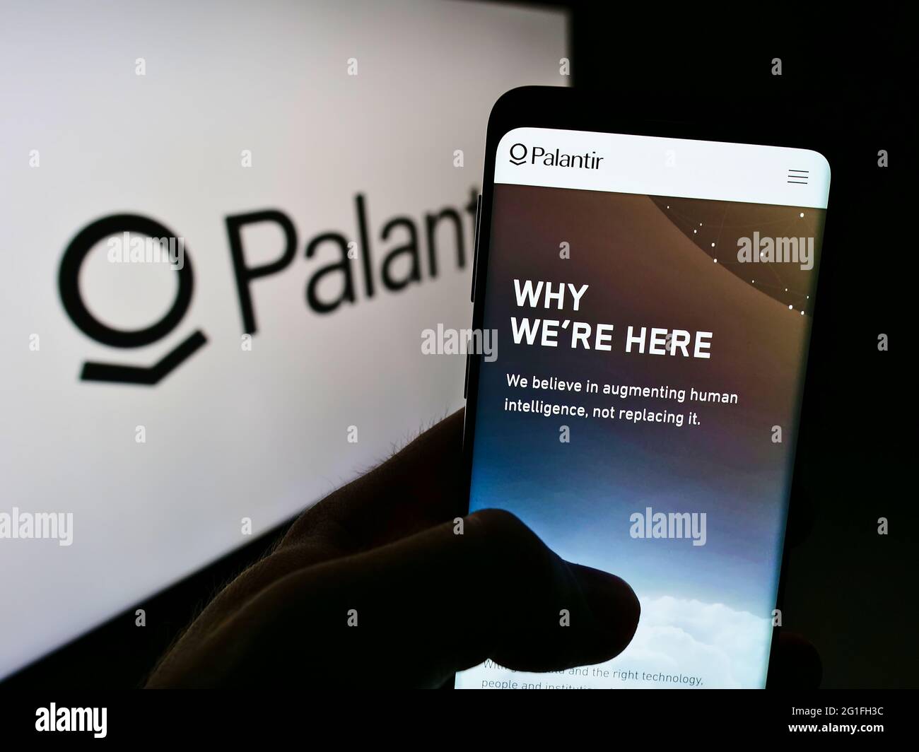 Person mit Mobiltelefon und Webseite des US-Softwareunternehmens Palantir Technologies Inc. Auf dem Bildschirm mit Logo. Konzentrieren Sie sich auf die Mitte des Telefondisplays. Stockfoto
