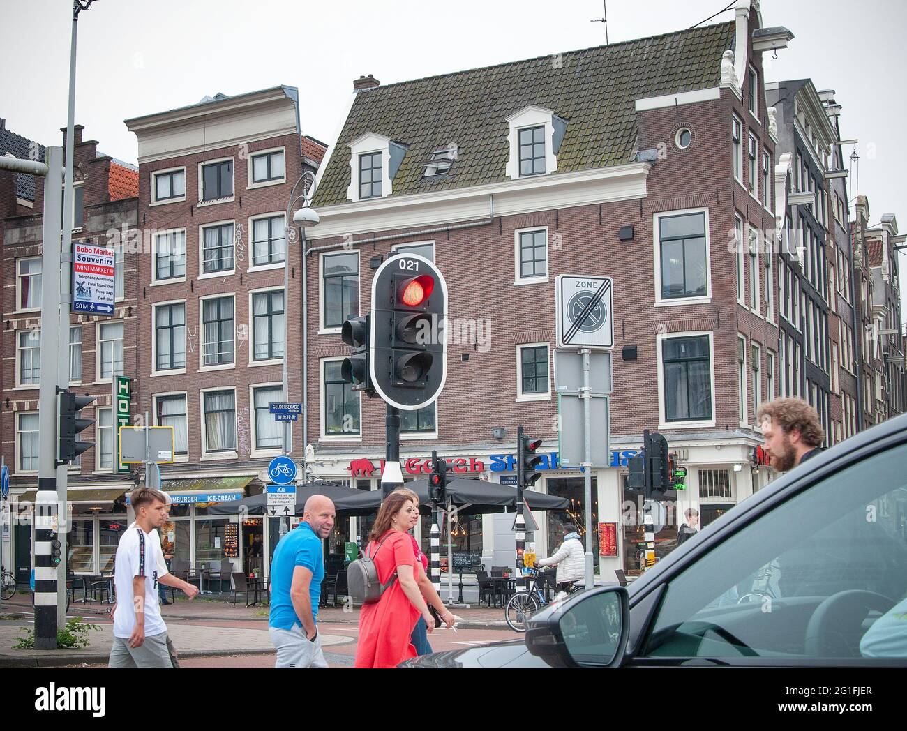 AMSTERDAM, NIEDERLANDE. 06. JUNI 2021. Schöne Aussicht auf Amsterdam mit typisch holländischen Häusern. Geschäfte auf der Straße. Menschen, die herumlaufen. Stockfoto